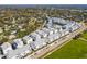 An aerial view captures a neighborhood showcasing uniform, modern townhomes, neatly arranged along a landscaped street at 2505 Boone Ct, Sarasota, FL 34237