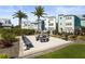 Outdoor common area with picnic tables, benches, and a grill, set against a backdrop of modern townhomes at 2505 Boone Ct, Sarasota, FL 34237