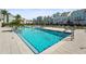 A refreshing community pool area with clear blue water, surrounded by modern townhomes, palm trees and lounge chairs at 2505 Boone Ct, Sarasota, FL 34237