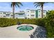 Community hot tub featuring blue tile and neutral colored pavers and lush landscaping with a chair nearby at 2505 Boone Ct, Sarasota, FL 34237