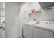 Neat laundry room with a washing machine, dryer, shelving, and a nearby doorway at 2505 Boone Ct, Sarasota, FL 34237