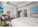 Bright and airy main bedroom with en-suite bathroom access, a stylish round mirror and wood floors at 2505 Boone Ct, Sarasota, FL 34237