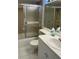 Bathroom featuring a tiled shower with a sliding glass door next to the toilet and sink at 2607 Woodgate Ln # K9, Sarasota, FL 34231