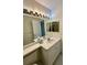 Bright bathroom featuring a white vanity, ample lighting, and a large mirror, providing a clean and functional space at 2607 Woodgate Ln # K9, Sarasota, FL 34231