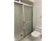 Bathroom shower with sliding glass door and white tiled walls next to white toilet at 2607 Woodgate Ln # K9, Sarasota, FL 34231