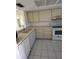 Bright kitchen featuring tile floor, white appliances, and ample cabinet space at 2607 Woodgate Ln # K9, Sarasota, FL 34231