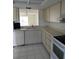 Well-lit kitchen includes white appliances, ample cabinet space, and tile flooring at 2607 Woodgate Ln # K9, Sarasota, FL 34231