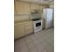 Kitchen area with white cabinets, tile floors, and white appliances including refrigerator and oven at 2607 Woodgate Ln # K9, Sarasota, FL 34231