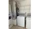 Functional laundry area featuring a white washer and dryer, shelving, and a utility area with a furnace at 2607 Woodgate Ln # K9, Sarasota, FL 34231