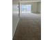 Inviting living room with carpeting, sliding glass doors, and mirrored accent wall at 2607 Woodgate Ln # K9, Sarasota, FL 34231