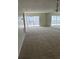 Spacious living room featuring neutral carpeting, sliding glass doors, and mirrored wall creating an open feel at 2607 Woodgate Ln # K9, Sarasota, FL 34231