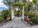 Outdoor garden area featuring an arbor, gravel pathway, and whimsical animal statuary at 333 Bayshore Dr, Venice, FL 34285