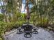 Outdoor patio with dining table and umbrella surrounded by lush landscaping, creating a private and inviting outdoor space at 333 Bayshore Dr, Venice, FL 34285