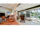 View of the sunroom and patio area with a large glass doors with natural light and beautiful greenery at 3610 Garden Lakes Clenet, Bradenton, FL 34203