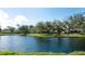 Scenic view of a tranquil pond surrounded by mature trees and well-maintained landscaping at 3610 Garden Lakes Clenet, Bradenton, FL 34203