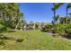 Grassy backyard, featuring a pond surrounded by lush vegetation, and a clear blue sky at 3803 54Th W Dr # 203, Bradenton, FL 34210