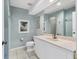 Cozy bathroom features a large mirror, neutral tile floor, and serene blue walls at 3803 54Th W Dr # 203, Bradenton, FL 34210