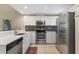 Bright kitchen featuring stainless steel appliances, tile backsplash, and white cabinetry at 3803 54Th W Dr # 203, Bradenton, FL 34210