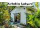 A backyard airbnb with lush landscaping and a sliding glass door entrance at 4062 S Shade Ave, Sarasota, FL 34231