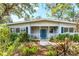 Inviting single-story home showcasing a quaint front porch with a vibrant blue front door at 4062 S Shade Ave, Sarasota, FL 34231
