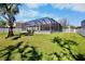 Backyard view showcasing a screened-in pool and well-maintained lawn at 4110 Noble Pl, Parrish, FL 34219
