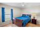 Cozy bedroom features a wooden bed frame and a window with blue curtains at 4110 Noble Pl, Parrish, FL 34219