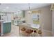 Eat-in kitchen featuring green cabinetry, white appliances, and an adjacent dining area at 4110 Noble Pl, Parrish, FL 34219