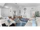 Bright living room with wood floors, white sofas, blue pillows, and a modern rug at 4202 Donnington Dr, Parrish, FL 34219