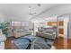 Open living space with wood floors, white sofas, blue pillows, ceiling fan, and a glimpse of the kitchen at 4202 Donnington Dr, Parrish, FL 34219