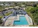 Aerial view of community pool, spa, clubhouse, and parking, surrounded by lush trees and manicured lawns at 4202 Donnington Dr, Parrish, FL 34219