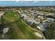 Aerial view of a neighborhood and home, adjacent to a golf course with sand traps at 4306 Presidential Avenue E Cir, Bradenton, FL 34203