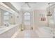Spacious bathroom with dual sinks, a large soaking tub, a window with shutters, and white tile flooring at 4306 Presidential Avenue E Cir, Bradenton, FL 34203