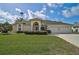 Inviting single-story home with a well-manicured lawn, a three-car garage, and an elegant arched entryway at 4306 Presidential Avenue E Cir, Bradenton, FL 34203