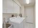 Well-lit laundry room featuring a sink, washer, dryer, and ample storage cabinets at 4306 Presidential Avenue E Cir, Bradenton, FL 34203
