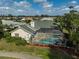 An aerial view of a home's rear, featuring a screened-in pool and spa, surrounded by lush landscaping at 4306 Presidential Avenue E Cir, Bradenton, FL 34203