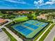 Aerial shot of well-maintained tennis courts with greenery, a pond and surrounding community at 4306 Presidential Avenue E Cir, Bradenton, FL 34203