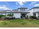 A well-maintained backyard features a lush lawn, landscaping, and a covered patio ideal for outdoor living and dining at 4793 Antrim Dr, Sarasota, FL 34240
