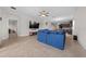 Bright living room with a large TV, ceiling fan, and an open floor plan leading to the kitchen at 4793 Antrim Dr, Sarasota, FL 34240