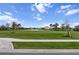 Street view features a sidewalk lined with green grass leading towards a scenic pond and other homes in the community at 4793 Antrim Dr, Sarasota, FL 34240