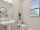 Bathroom with a white pedestal sink, modern mirror and fixture, and large window for natural light at 5074 Surfside Cir, Bradenton, FL 34211