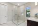 Modern bathroom featuring a glass-enclosed shower, stylish tile accents, and a window offering natural light at 5074 Surfside Cir, Bradenton, FL 34211