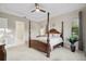 Comfortable bedroom featuring a four-poster bed, ceiling fan, and large window for natural light at 5074 Surfside Cir, Bradenton, FL 34211