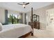 Serene bedroom with a four-poster bed, dresser, and expansive windows overlooking lush greenery at 5074 Surfside Cir, Bradenton, FL 34211