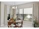 Cozy dining area featuring a modern light fixture, large window, and a view of the outdoor scenery at 5074 Surfside Cir, Bradenton, FL 34211