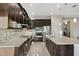 Kitchen with stainless steel appliances, a tile backsplash, granite countertops, and dark wood cabinetry at 5074 Surfside Cir, Bradenton, FL 34211