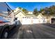 Exterior view of garages with green roofs and a service vehicle parked in front under a bright blue sky at 5122 Northridge Rd # 110, Sarasota, FL 34238