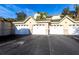 View of multi-unit garages with white doors and a green roof for secure parking at 5122 Northridge Rd # 110, Sarasota, FL 34238