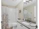 Well-lit bathroom featuring a shower-tub combo, tile surround, and vanity with gray countertop at 5320 Crestlake Blvd # 26, Sarasota, FL 34233
