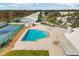 Community pool and tennis court in an aerial view, with beautiful landscaping and clear blue skies at 5320 Crestlake Blvd # 26, Sarasota, FL 34233