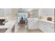 Bright kitchen with white cabinets, countertops, and stainless steel sink overlooking an indoor dining and living area at 5320 Crestlake Blvd # 26, Sarasota, FL 34233